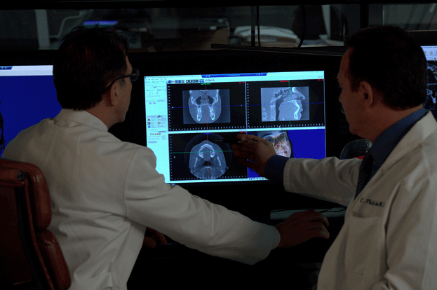 doctors looking at a patients x-rays on a monitor