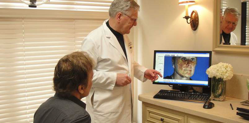 doctor with patient showing digital imaging of the face